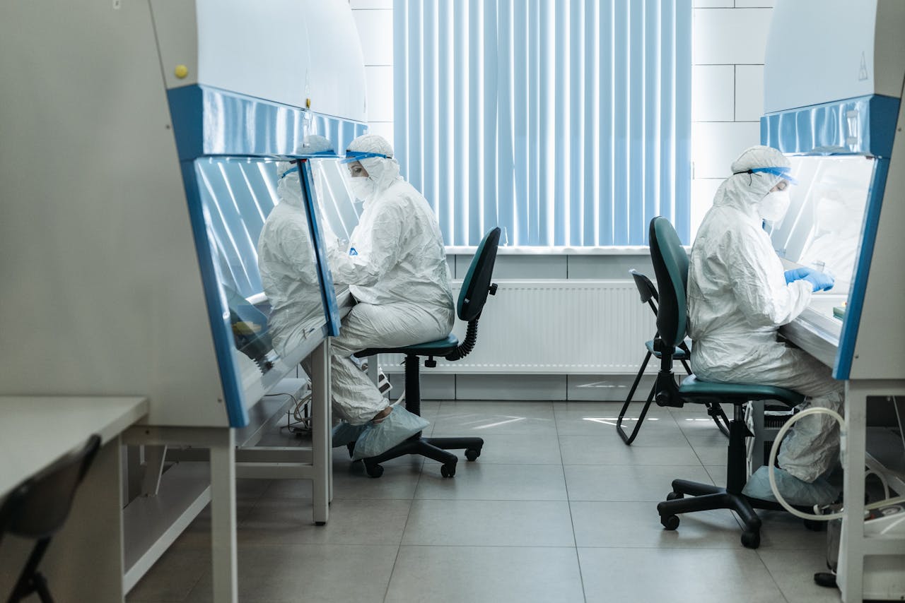 services-03 Scientists in protective suits working in laboratory cleanroom, conducting experiments.